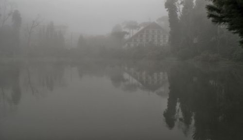 Scenic view of lake against sky during foggy weather