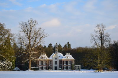 House on field against sky during winter