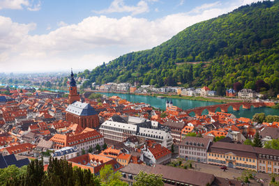 High angle view of townscape by river against sky