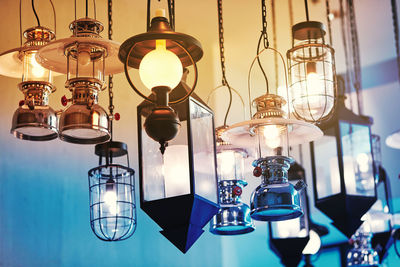 Low angle view of illuminated light bulb hanging from ceiling
