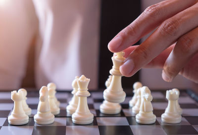 Midsection of businessman playing chess in office