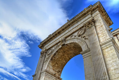 Low angle view of porta reale arch against cloudy sky