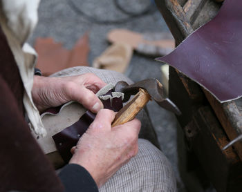 Close-up of cobbler working while holding hammer
