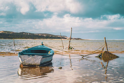 Boat moored on sea against sky