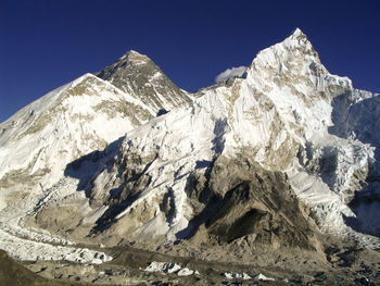 Scenic view of snowcapped mountains against clear blue sky