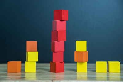 Stack of multi colored blocks on table against gray background