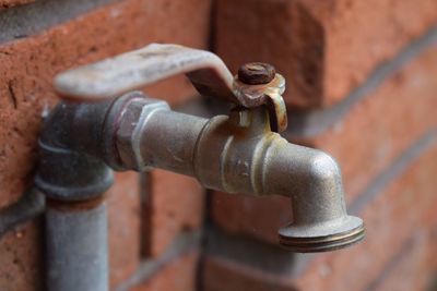 Close-up of faucet on brick wall