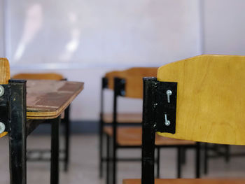 Close-up of seats on table against wall