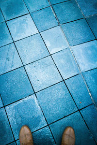 Low section of person standing on tiled floor