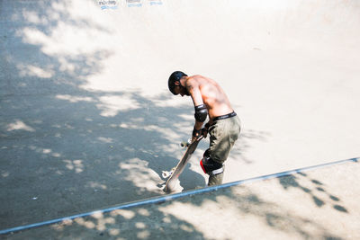 High angle view of shirtless man skateboarding