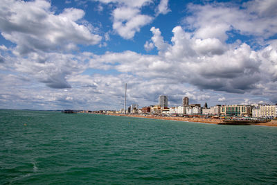 View of buildings in sea against cloudy sky