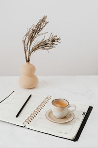 Coffee cup and book on table