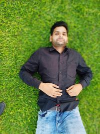 Portrait of young man standing on grass