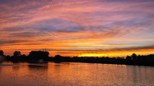 Scenic view of lake against romantic sky at sunset