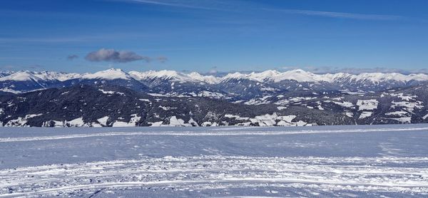 Scenic view of snowcapped mountains against blue sky