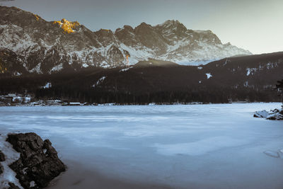 Scenic view of lake and snowcapped mountains against sky