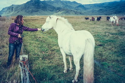 Man standing on field against mountains