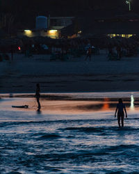 Silhouette people on beach at night