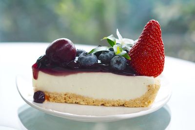 Close up mixed berries fruits with blueberry sauce cheese tart