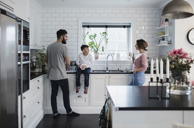 Father and mother with son in kitchen at home