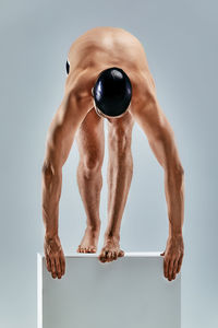 Full length of shirtless young man against white background