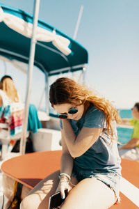 Woman wearing sunglasses sitting outdoors