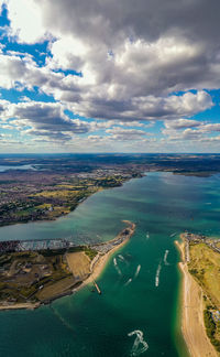 High angle view of city by sea against sky