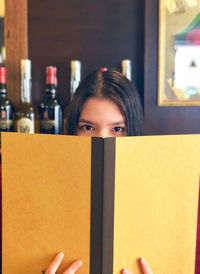 Portrait of young woman reading book at home