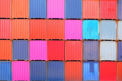 Stack of multi colored chairs on pier at harbor