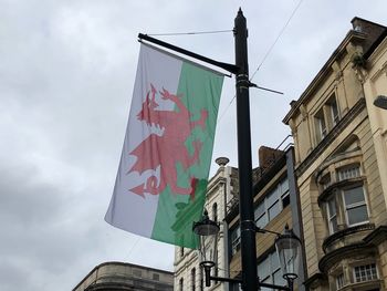 Low angle view of flags hanging on building against sky