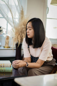 Young woman using mobile phone at home