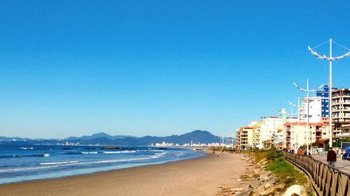 View of beach against clear blue sky