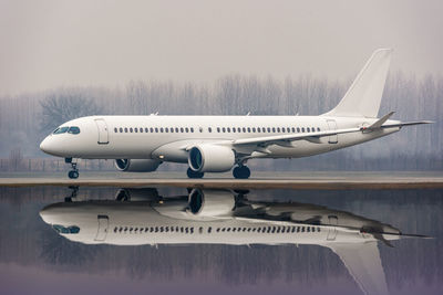 Reflection of airplane in water on airport