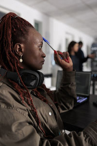 Side view of woman applying make-up on table