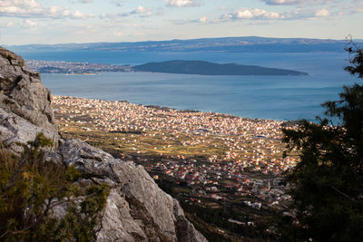 High angle view of townscape by sea against sky