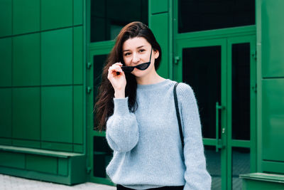 Portrait of beautiful woman standing against wall