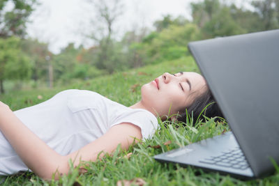 Midsection of woman lying down on grass