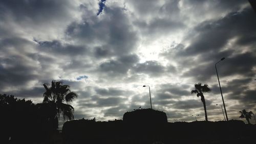 Low angle view of silhouette trees against sky