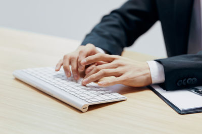 Midsection of businessman using laptop on table