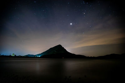 Scenic view of lake against sky at night