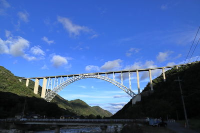 Low angle view of bridge over river against sky