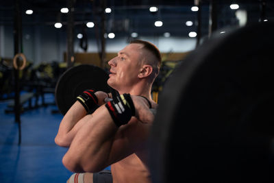 Adult sportsman squatting with barbell