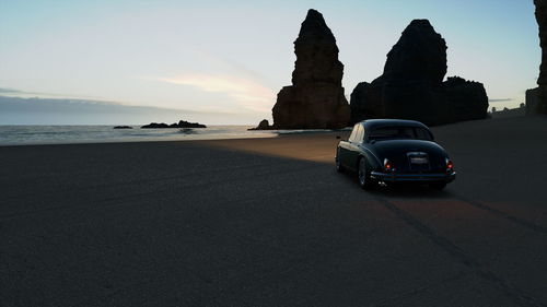 Cars on beach against sky during sunset