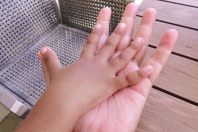 Close-up of child's and adult's hands