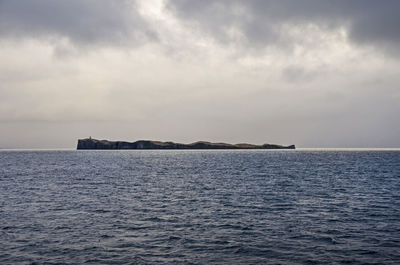 One of the many islands in breiðafjörður in iceland under a dramatic cloudy sky