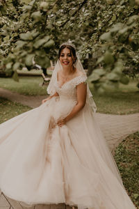 Portrait of young woman standing at park