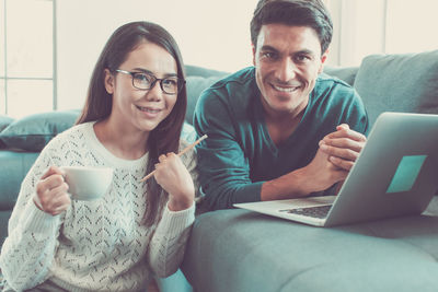 Portrait of smiling young man using laptop