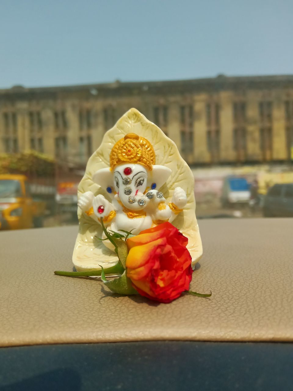 yellow, architecture, flower, representation, nature, celebration, sky, art, day, city, human representation, built structure, no people, outdoors, building exterior, tradition, red, focus on foreground, statue, creativity, flowering plant, clothing