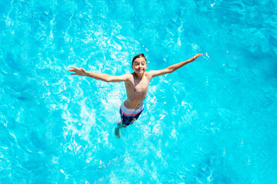 Rear view of woman swimming in pool