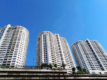 Low angle view of modern buildings against blue sky
